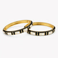 Black and white bangle set with geometric enamel pattern, angled view