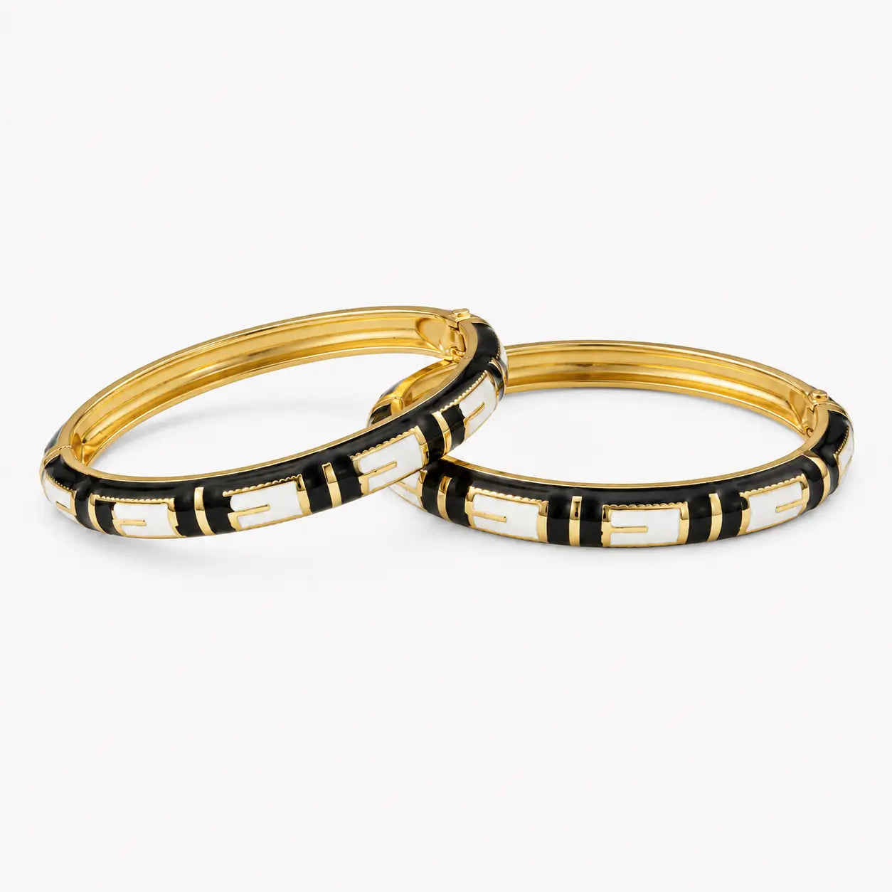 Black and white bangle set with geometric enamel pattern, angled view