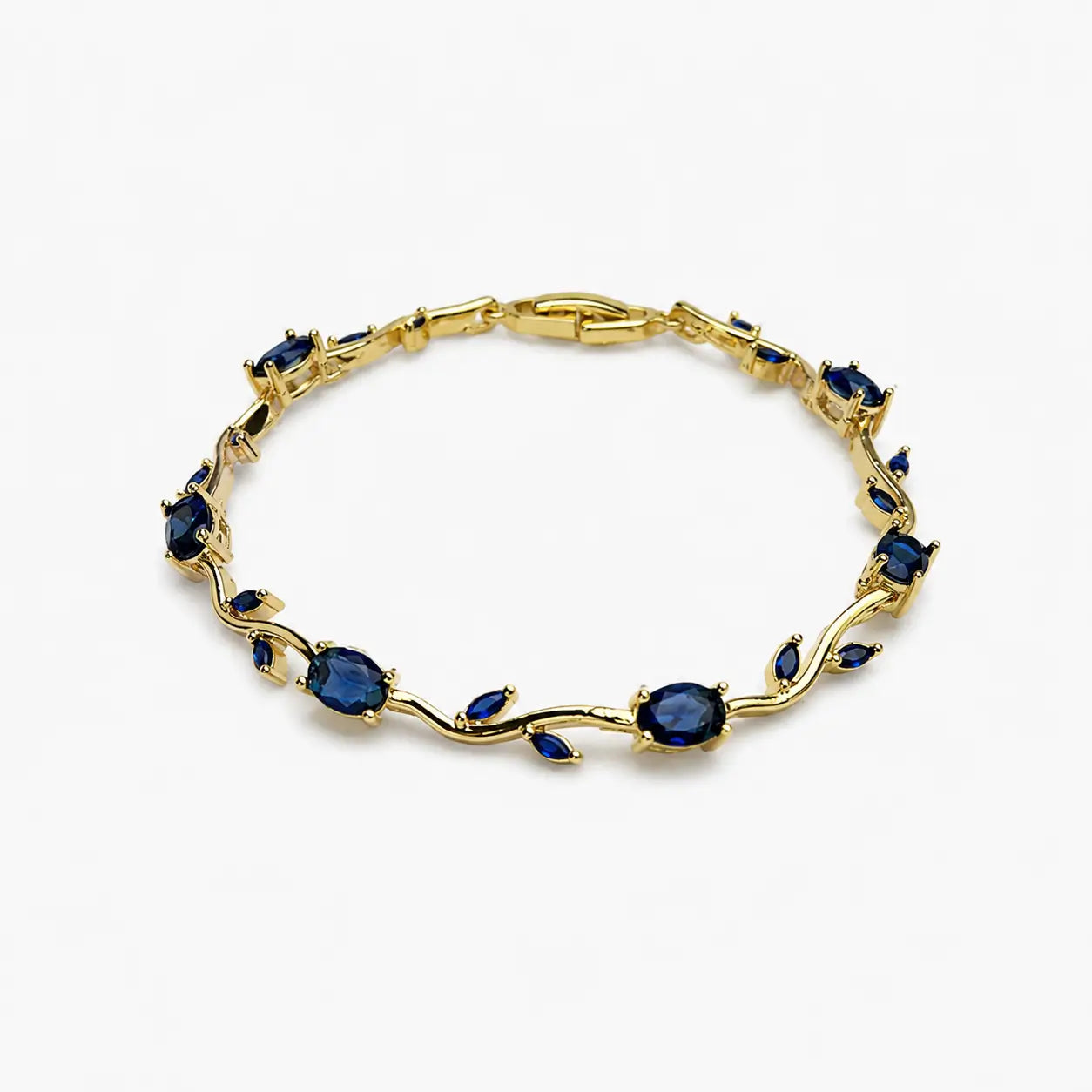 Stone hand bracelet with dark blue oval and leaf-shaped stones in a polished gold-colour vine design, angled view.