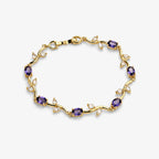 Bracelets for women with purple oval stones and clear leaf-shaped stones on a polished gold-colour vine design, angled view.