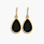 Black teardrop earrings with gold hooks on a white background