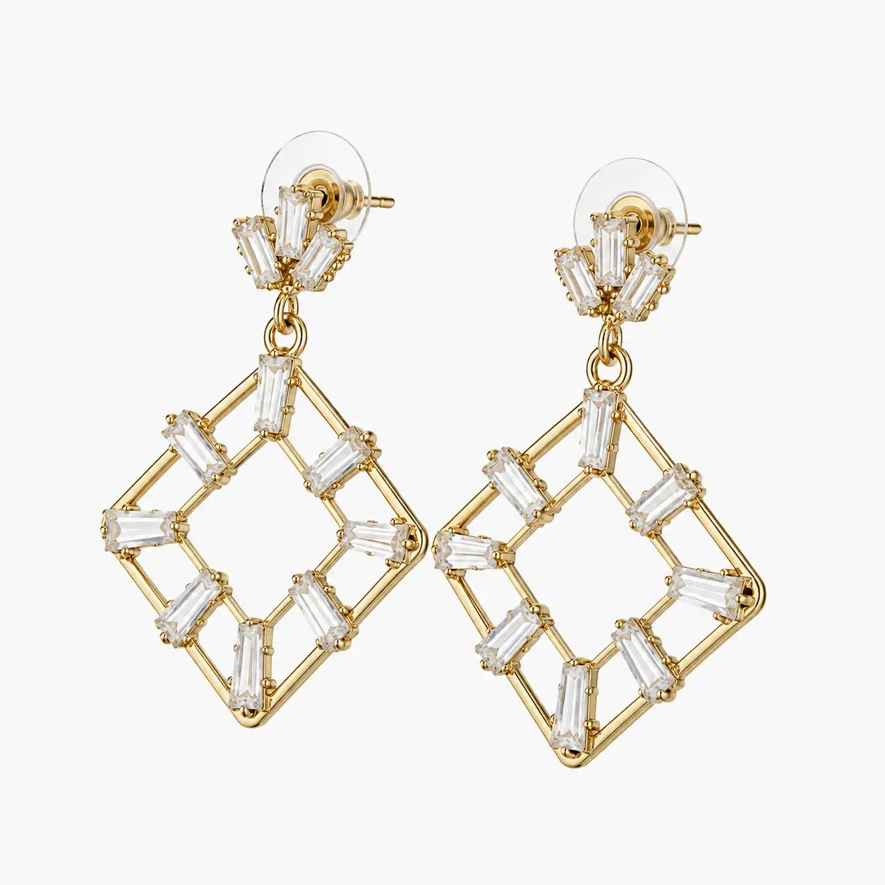 Party wear earrings with gold-tone diamond-shaped drops and clear rectangular stone-look accents, angled view
