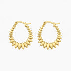 Hoop earrings in gold tone with graduated polished oval bead-like elements, angled view