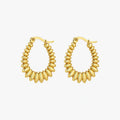 Hoop earrings with gold-tone graduated oval bead-like elements arranged around the full hoop, front view