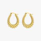 Hoop earrings with gold-tone graduated oval bead-like elements arranged around the full hoop, front view