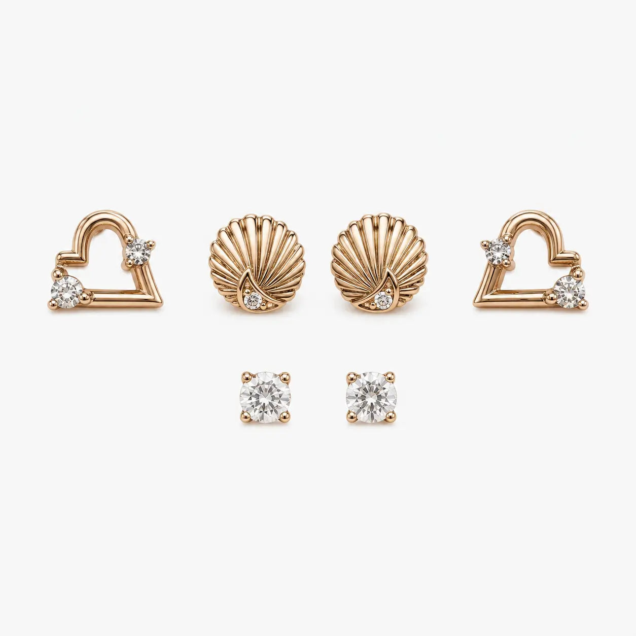  Stud earrings set with rose-gold-colour heart, shell and round clear stone designs arranged in a front view.