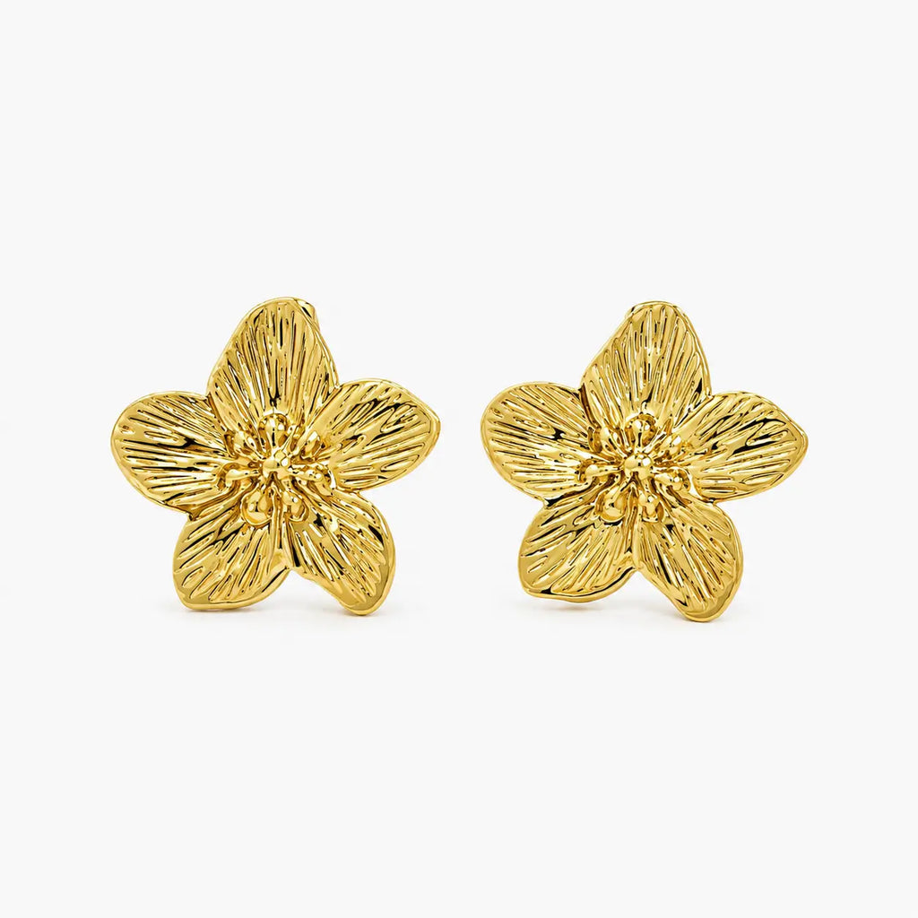 Close-up of textured gold-tone flower stud earrings showing petal detailing
