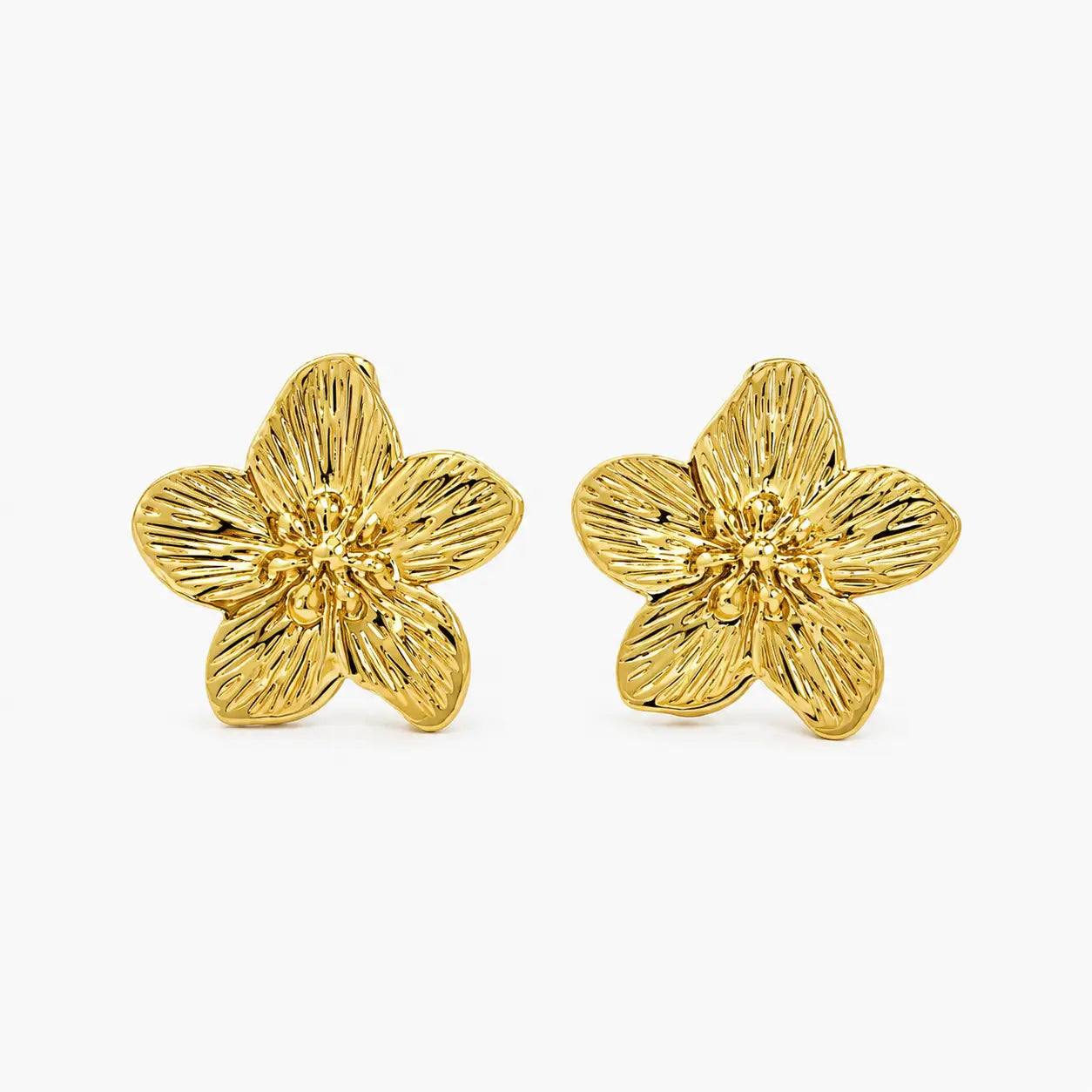 Close-up of textured gold-tone flower stud earrings showing petal detailing