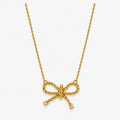 clear-accent bow pendant necklace on twisted gold-colour chain