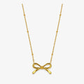 gold-tone bow pendant necklace with spaced round bead accents on fine chain