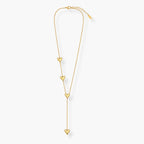 Close-up of gold-tone heart charm on Y-shaped necklace