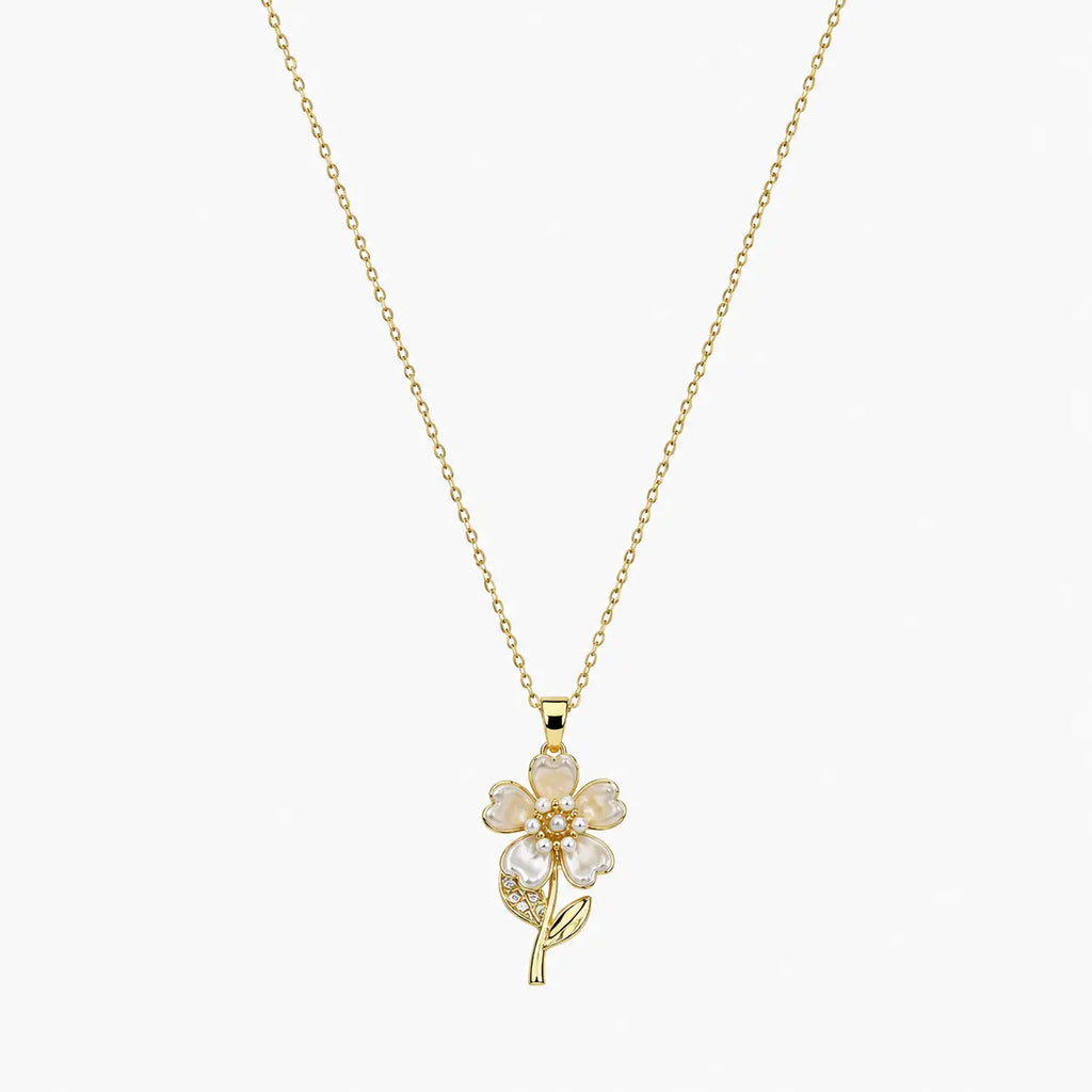 Close-up of a gold-tone pendant necklace with pearlescent flower petals, pearl-like centre and delicate stem.