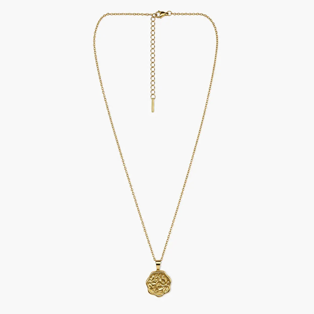 Full view of the gold-tone pendant necklace with floral coin charm, fine chain, clasp and long extender.