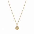  Close-up of a gold-tone pendant necklace with four-lobed clover shape and clear centre stone.