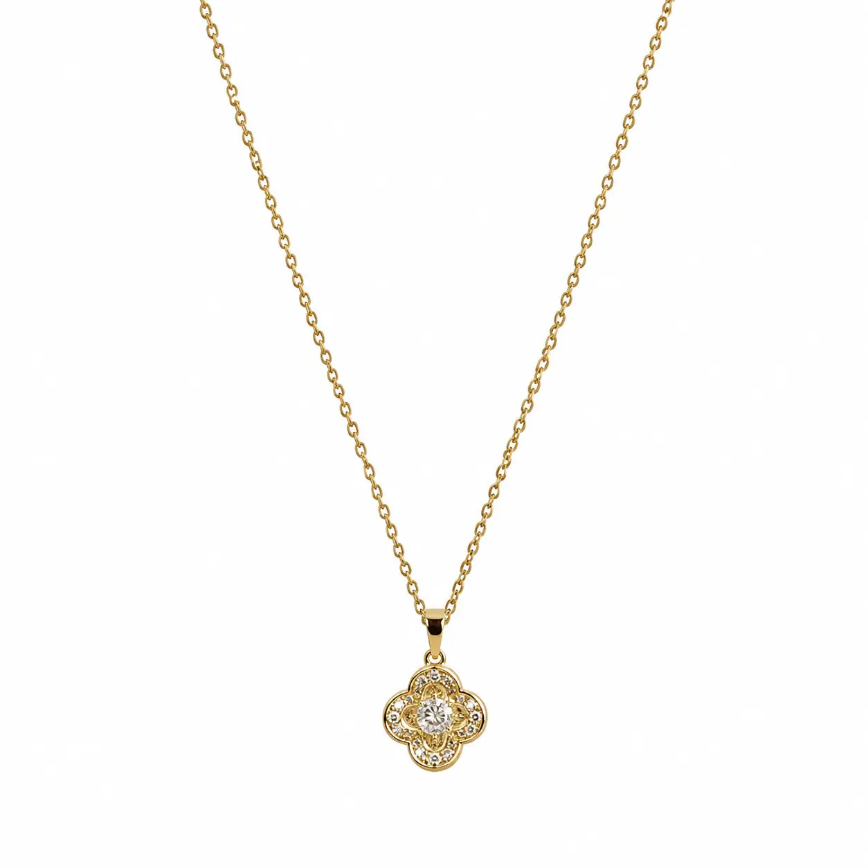  Close-up of a gold-tone pendant necklace with four-lobed clover shape and clear centre stone.