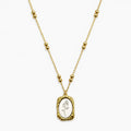 Close-up of a Two-tone chain necklace with paired beads and a textured rectangular rose pendant.