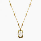 Close-up of a Two-tone chain necklace with paired beads and a textured rectangular rose pendant.