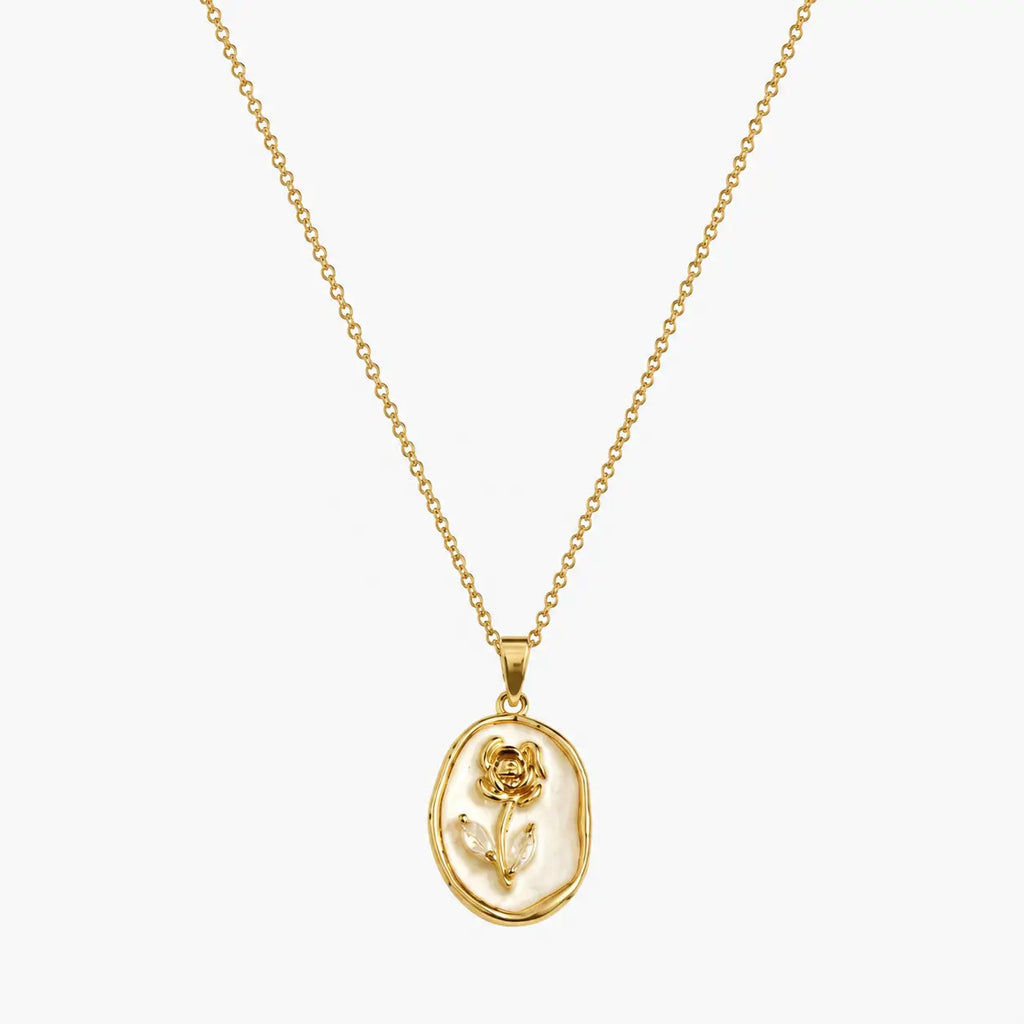Pendant necklace with gold-tone oval frame, raised rose motif and pearlescent-look white centre, close-up view