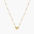 Necklace for girls with gold-tone bow charm and evenly spaced polished bead accents, close-up front view