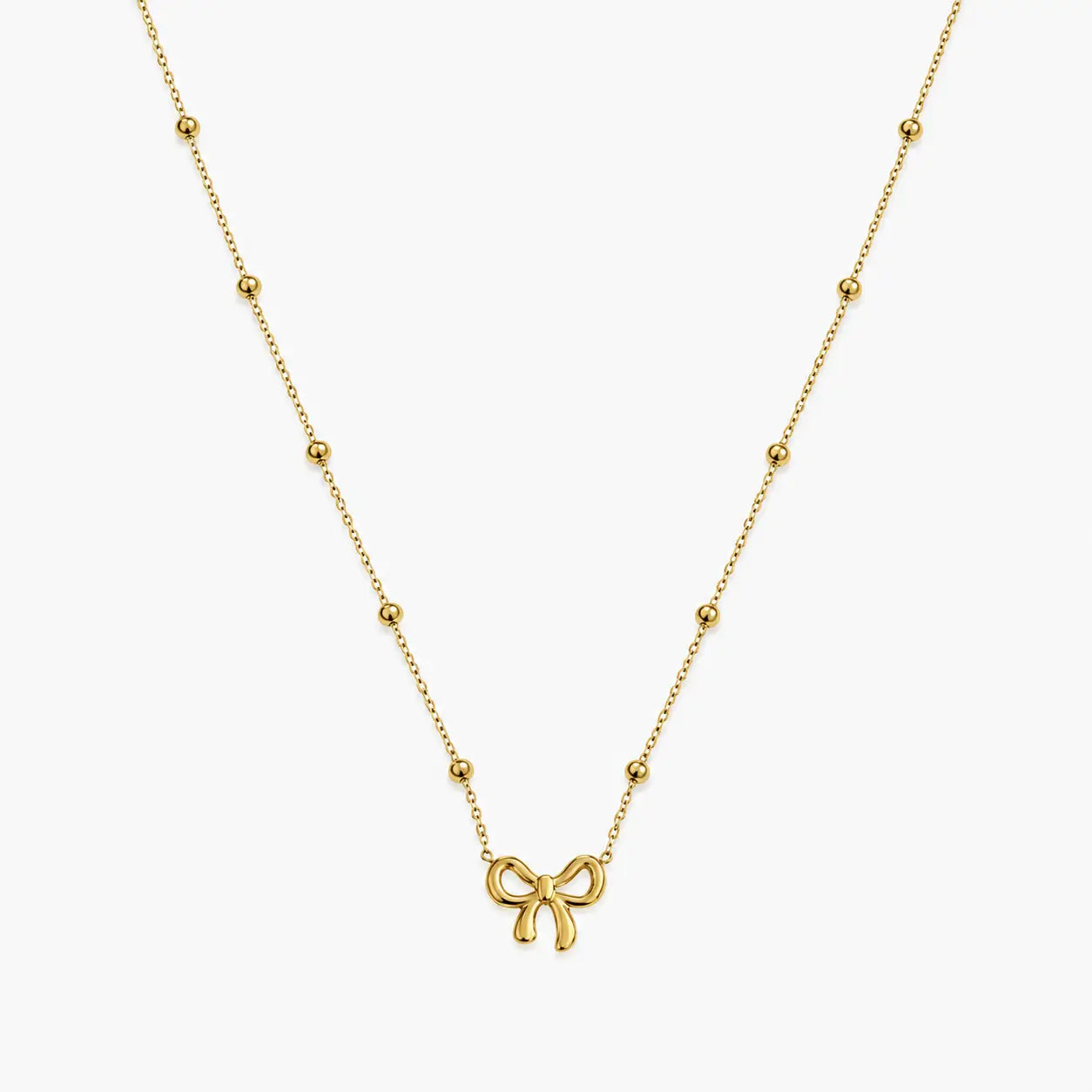 Necklace for girls with gold-tone bow charm and evenly spaced polished bead accents, close-up front view