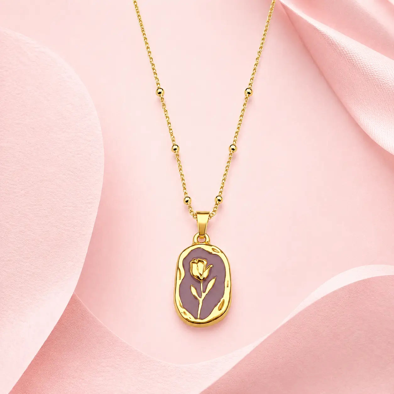 Gold-tone pendant necklace with beaded chain and gold rose design